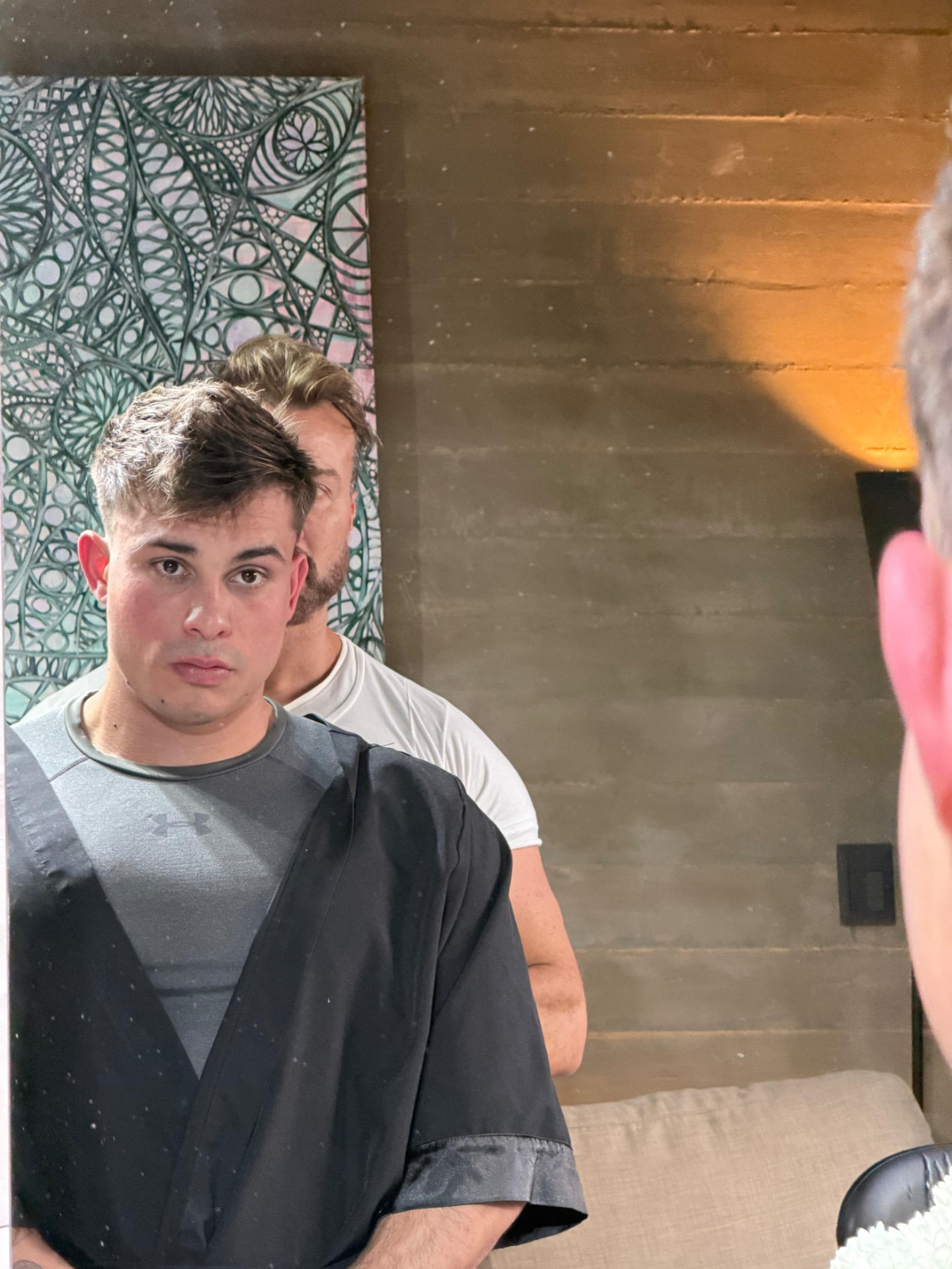 Corte masculino texturizado en proceso frente al espejo del estudio